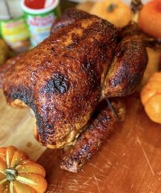 a whole chicken sitting on top of a wooden cutting board next to some oranges