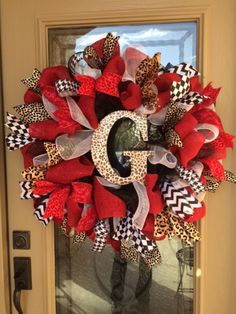 a red and black wreath with the letter g on it's front door,