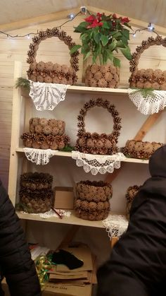 a shelf filled with lots of cakes and cupcakes next to a potted plant