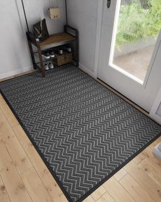 a black and white rug with an area rug on the floor in front of a door