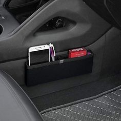 the interior of a car with a cell phone and pen holder in the passenger seat