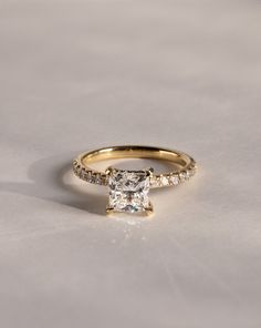 a gold engagement ring with a princess cut diamond