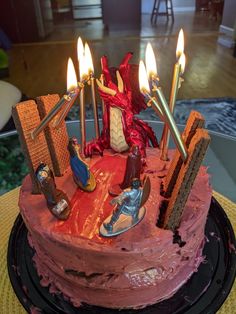 a birthday cake with candles on top of it in the shape of a dragon and other items