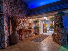 an entrance to a house with stone walls and doors leading into the living room area