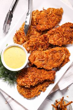 some fried food on a white plate with dipping sauce