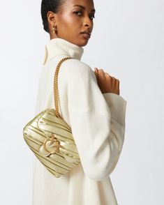 Small Baby Love Bag Puff crossbody bag in recycled-fibre leather-effect fabric with metallic golden finish and irregular pleating. This soft bag will give your elegant and special-evening outfits that sought-after finishing touch; the sliding chain strap with shoulder pad allows it to be worn either crossbody or, when doubled, on the shoulder. The bag's flap is complete with the iconic, antique gold-electroplated metal Love Birds Diamond Cut buckle, while the microsuede-lined interior features a Gold Luxe Shoulder Bag With Dust Bag, Luxe Gold Shoulder Bag With Dust Bag, Gold Luxe Crossbody Shoulder Bag, Calf Length Skirts, Soft Bag, Elegant Baby, Small Baby, Evening Outfits, Boot Pumps