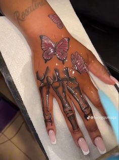 a woman's hand with butterflies painted on it