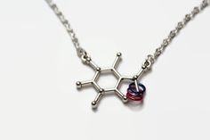 "Bisexual caffeine necklace This necklace has the molecular structure of caffeine as the focal point.  It also has jump rings in the colours of the bisexual pride flag.  Caffeine is what many people depend on to be functional humans throughout the day, with most getting it through the consumption of coffee or tea, while others get it from soda/pop/soft drinks or even energy drinks. If you want to celebrate your love of caffeine and your bi pride at the same time, this is the necklace for you.  C Bisexual Necklace, Serotonin Necklace, Bisexual Pride Flag, Pride Necklace, Happy Jewelry, Molecular Structure, Soda Pop, Pride Flag, Soft Drinks