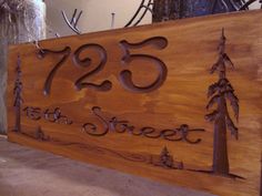 a wooden sign with the number twenty five and two pine trees on it that says 25th street