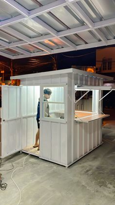 a man standing inside of a white container