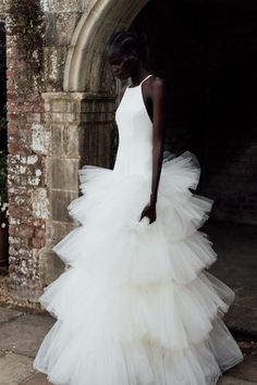 a woman in a white dress standing outside