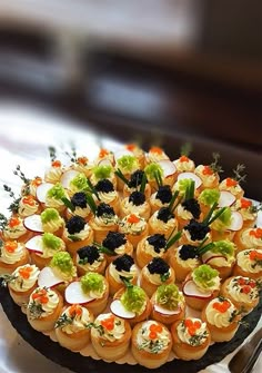 a platter filled with small appetizers sitting on top of a table