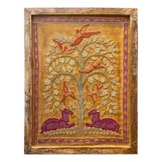 an embroidered wall hanging with two animals and a tree in the center, on a white background