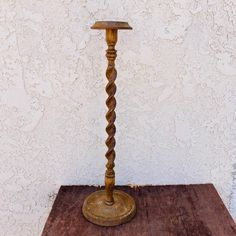 a wooden table with a candle holder on it and a white wall in the background