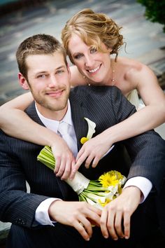 a man and woman are posing for a photo with flowers in their lapel bouquets