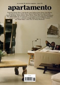 a magazine cover with people laying on couches and tables in the living room area