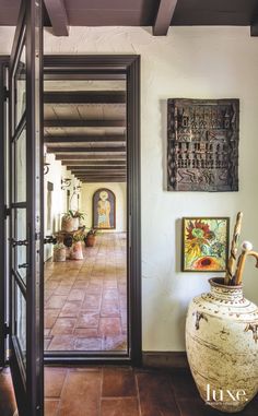 an entry way with vases and paintings on the wall