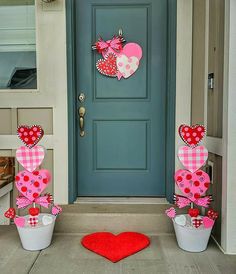 two buckets with hearts on them are sitting in front of a door decorated for valentine's day