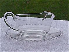 a clear glass bowl on a white tablecloth with grass in the backround