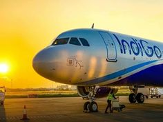 an airplane is parked on the tarmac with people walking around it at sunset or dawn