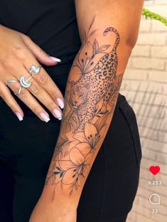 a woman's arm with a leopard and flowers tattoo on the left side of her body