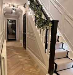 the stairs in this house are decorated with garlands and greenery for an elegant touch