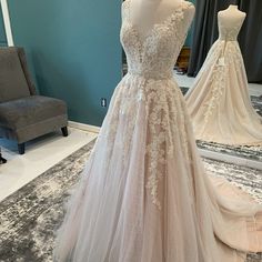 a wedding dress on display in front of a mirror with other gowns behind it