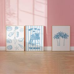 three framed art pieces on the floor in front of pink walls with palm trees and seashells