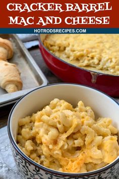 a bowl filled with macaroni and cheese on top of a table next to bread