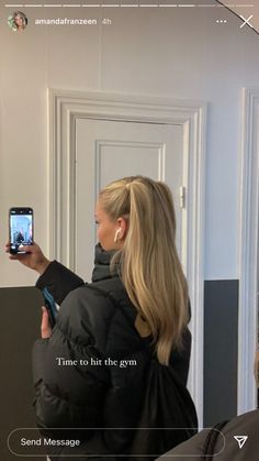 a woman is taking a selfie with her cell phone in front of the door