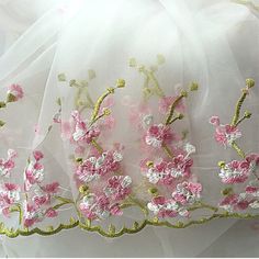 a white veil with pink flowers on it