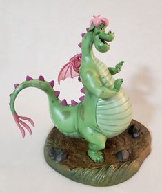 a green dragon figurine sitting on top of a rock