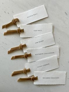 five pieces of paper with labels on them sitting on a white table top next to each other