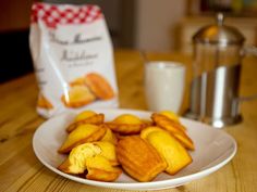 a white plate topped with cheesy potatoes next to a bag of milk