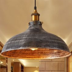 an industrial style pendant light hanging from the ceiling in a kitchen area with tile flooring