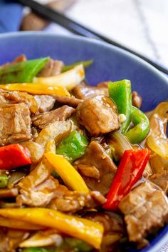 a blue bowl filled with meat and vegetables