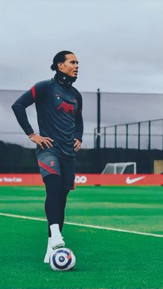 a man standing on top of a soccer field with his hands on his hips as if he's ready to kick the ball