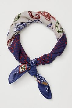 a blue and white scarf tied to a headband on a white surface with red, green, and blue designs