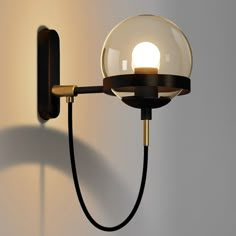 a wall light with a glass ball on the side and a black cord attached to it