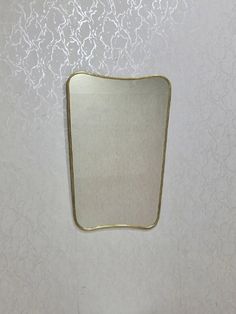 a white wall with a mirror hanging on it's side