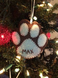 a dog paw ornament hanging from a christmas tree