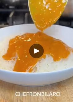 someone is pouring sauce on rice in a bowl with an orange peel sticking out of it