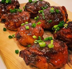 chicken wings with sauce and green onions on a cutting board