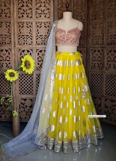 Made to Order/Measurement/Custom Order Lehenga - Color : Yellow - Fabric : Organza with Gold Foil Print and Mirror Border - Fully flared Paneled (kalidaar) lehenga  - Peach Embroidered Spaghetti Blouse - Pure Organza Grey Dupatta with Mirror Border - Drawstring closure with Tassel - Can can attached PLEASE NOTE: BUYERS ARE RESPONSIBLE FOR ANY CUSTOMS AND IMPORT TAXES THAT MAY APPLY. Fabric Care : Dry Clean Only Disclaimer: Please note the photographs are taken by mobile camera in sunlight The ac Lemon Yellow Lehenga Color Combos, Fitted Wedding Dress With Gota Work, Fitted Sharara With Gota Work For Reception, Fitted Lehenga With Gota Work For Wedding, Fitted Organza Choli With Dori Work, Fitted Yellow Sharara With Sheer Dupatta, Fitted Wedding Lehenga With Gota Work, Fitted Gota Work Set For Reception, Fitted Sets With Gota Work For Reception