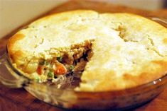 a close up of a pie in a glass dish on top of a wooden table