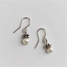 Small silver earrings with an asian silver ornament and fresh water pearls. You can buy the pair or a single earring. Dainty Silver Pearl Earrings For Formal Events, Dainty Silver Pearl Earrings For Formal Occasions, Silver Dainty Pearl Earrings For Formal Occasions, Nickel-free Silver Drop Pearl Earrings, Dainty Nickel-free Pearl Earrings, Dainty Silver Pearl Earrings For Pierced Ears, Silver Earrings With Pearl Charm As Gift, Dainty Teardrop Pearl Earrings In Sterling Silver, Dainty Silver Hypoallergenic Earrings