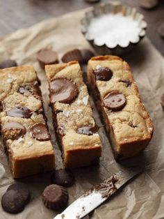 chocolate chip cookie bars cut into squares on top of wax paper next to a knife