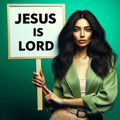 a woman holding a sign that says jesus is lord