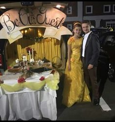 a man and woman in formal wear standing next to a table with food on it