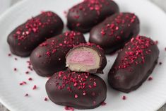 chocolate covered cookies with pink sprinkles on a baking sheet